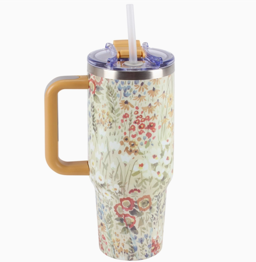 Floral-patterned travel mug with a handle on a white background
