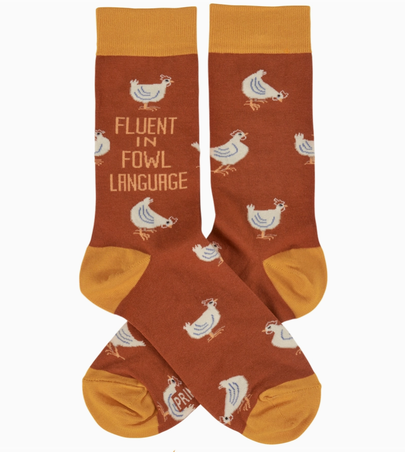 Pair of orange novelty socks featuring chicken designs and phrase "fluent in fowl language," on a white background.
