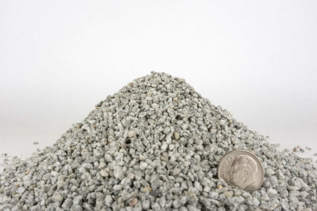 Pile of small stones with a dime for scale on a white background