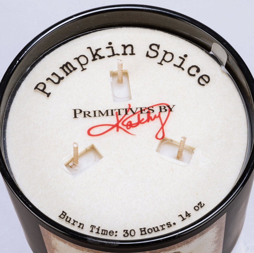 Pumpkin spice candle with 'Primitives by Kathy' branding on a light gray background