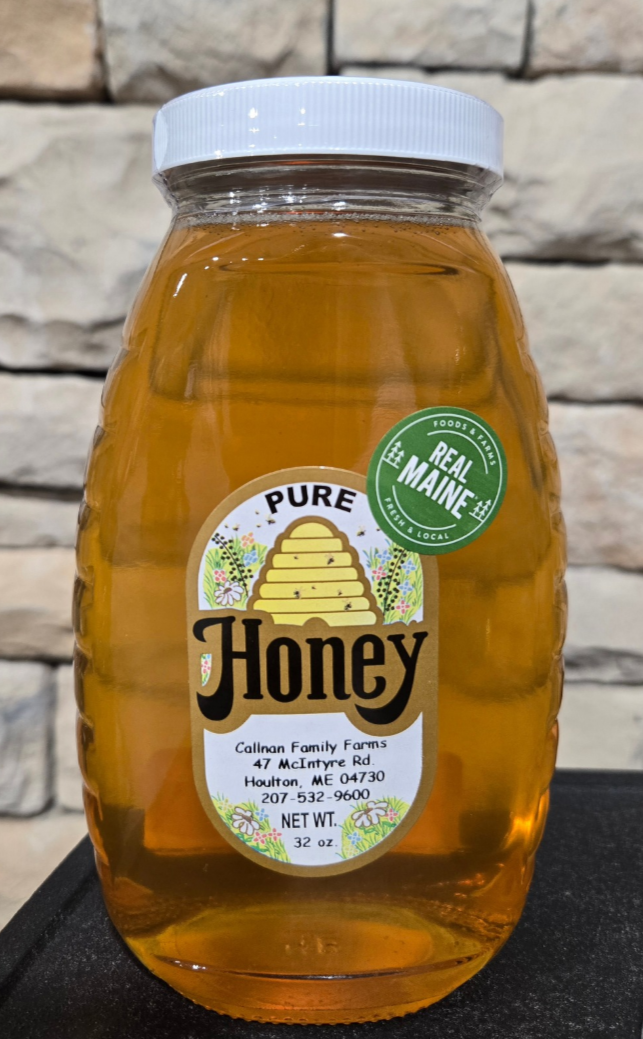 Jar of honey with a label on a stone surface