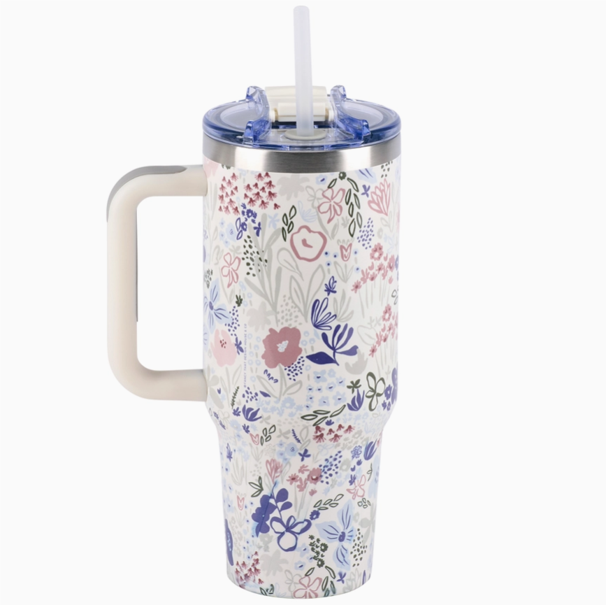 Floral-patterned tumbler with handle and straw on a white background