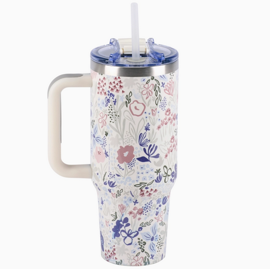 Floral-patterned tumbler with handle and straw on a white background
