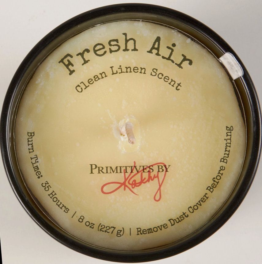 Candle with 'Fresh Air' scent and 'Primitives by Kathy' branding on a white background