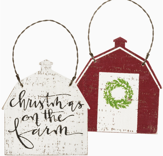 Two Christmas-themed house-shaped signs with 'Christmas on the Farm' text and a red barn design.