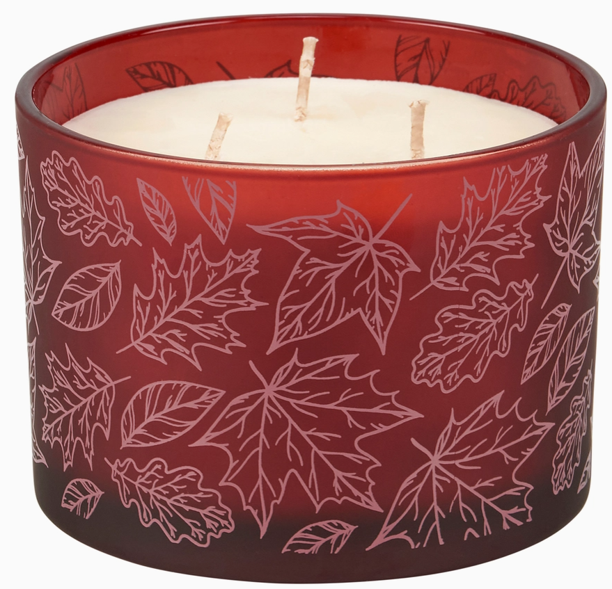 Red candle with leaf pattern on a white background
