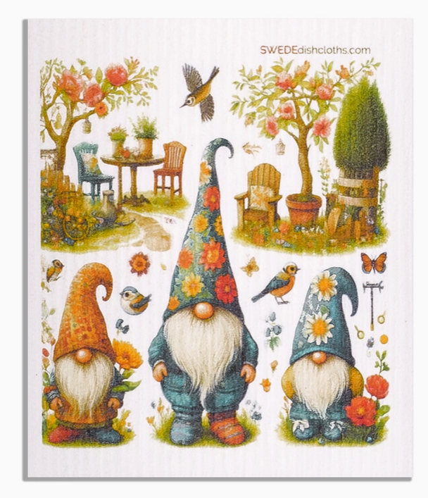 Decorative dishcloth with gnomes, flowers, and a garden scene on a white background.