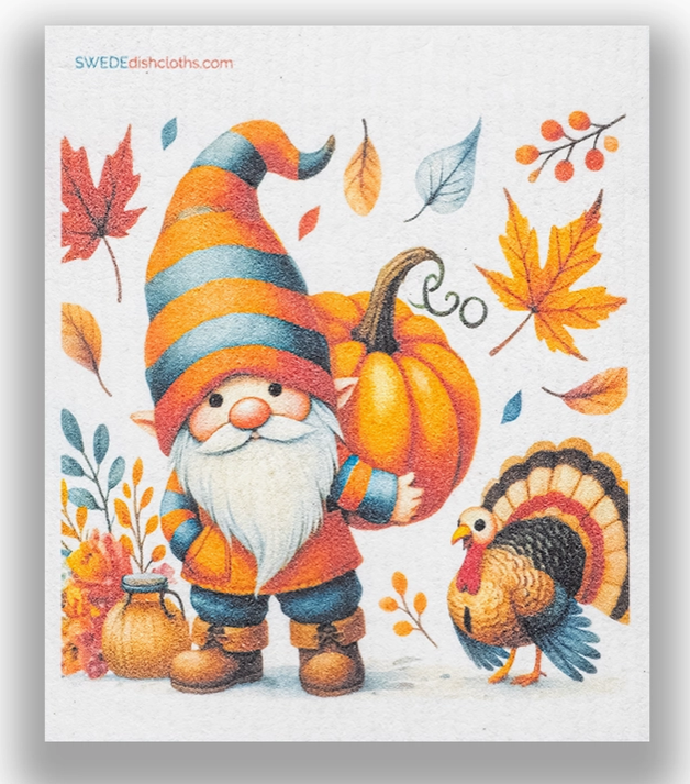 Decorative towel with a gnome holding a pumpkin, surrounded by autumn leaves and a turkey.