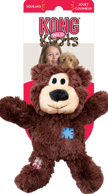 Kong Wild Knots plush bear dog toy attached to packaging with a child and dog on a white background