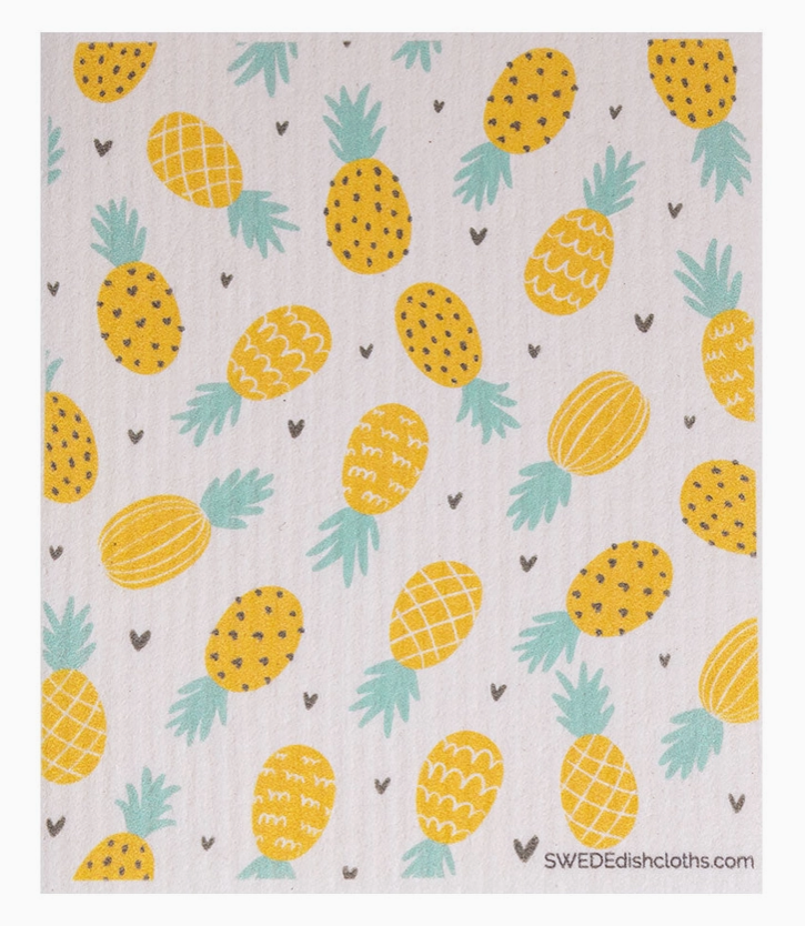 Patterned cloth with yellow pineapples and green leaves on a light background
