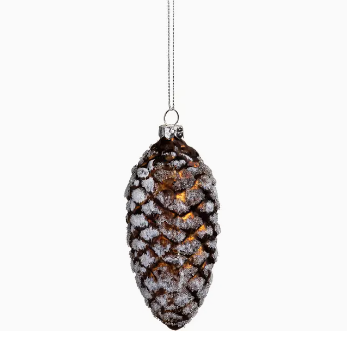 Decorative pine cone ornament with snow effect on a white background