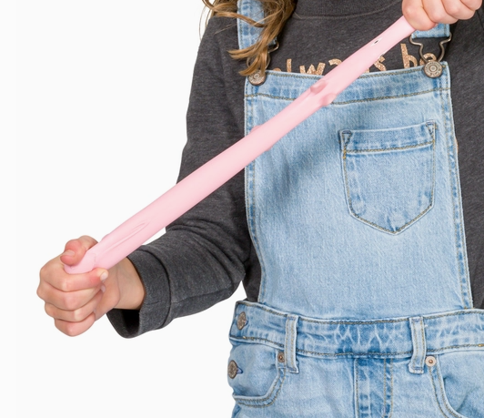 Person wearing denim overalls holding a pink object against a white background