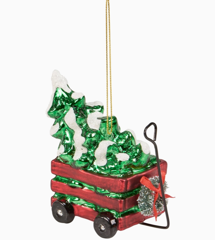 Christmas tree ornament in a red wagon with a gold hanging string on a white background