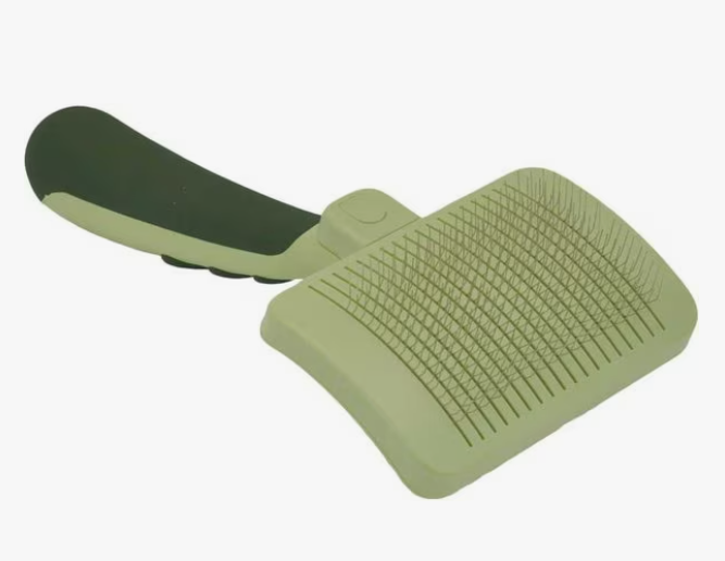 Green pet grooming brush on a white background