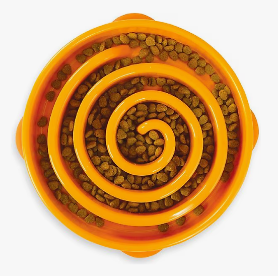Orange pet food bowl with a spiral design filled with kibble on a white background