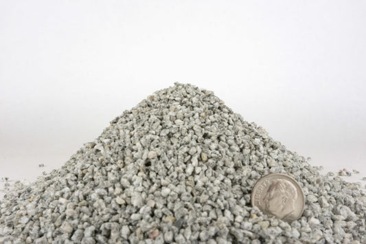 Pile of small stones with a dime for scale on a white background