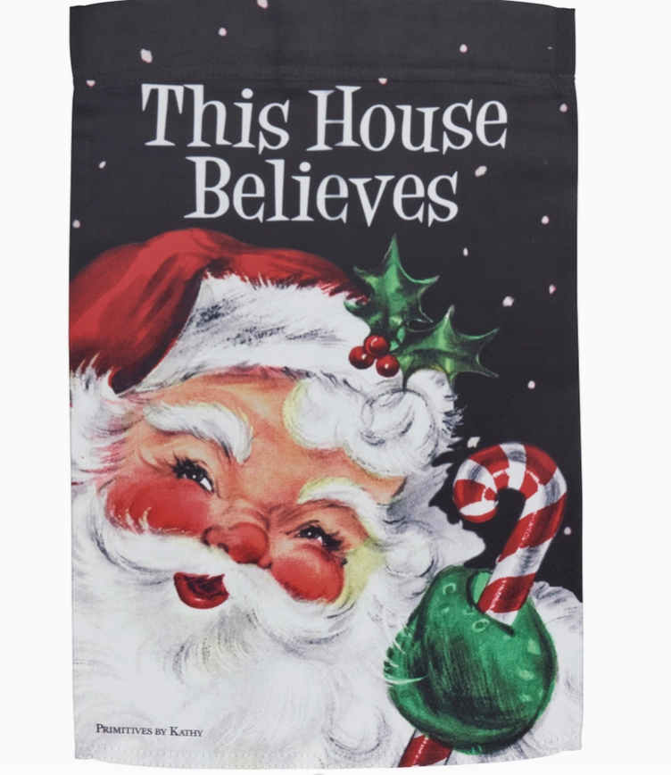 Decorative flag with Santa Claus and 'This House Believes' text on a black background.