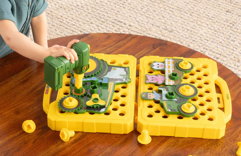 Child playing with a toy construction set on a wooden table