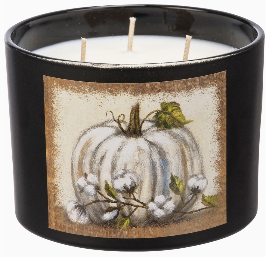 Black candle jar with a decorative label featuring a white pumpkin and cotton plant on a beige background.